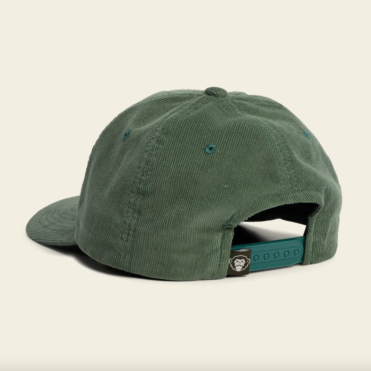 Green cap with a brand logo on a beige background