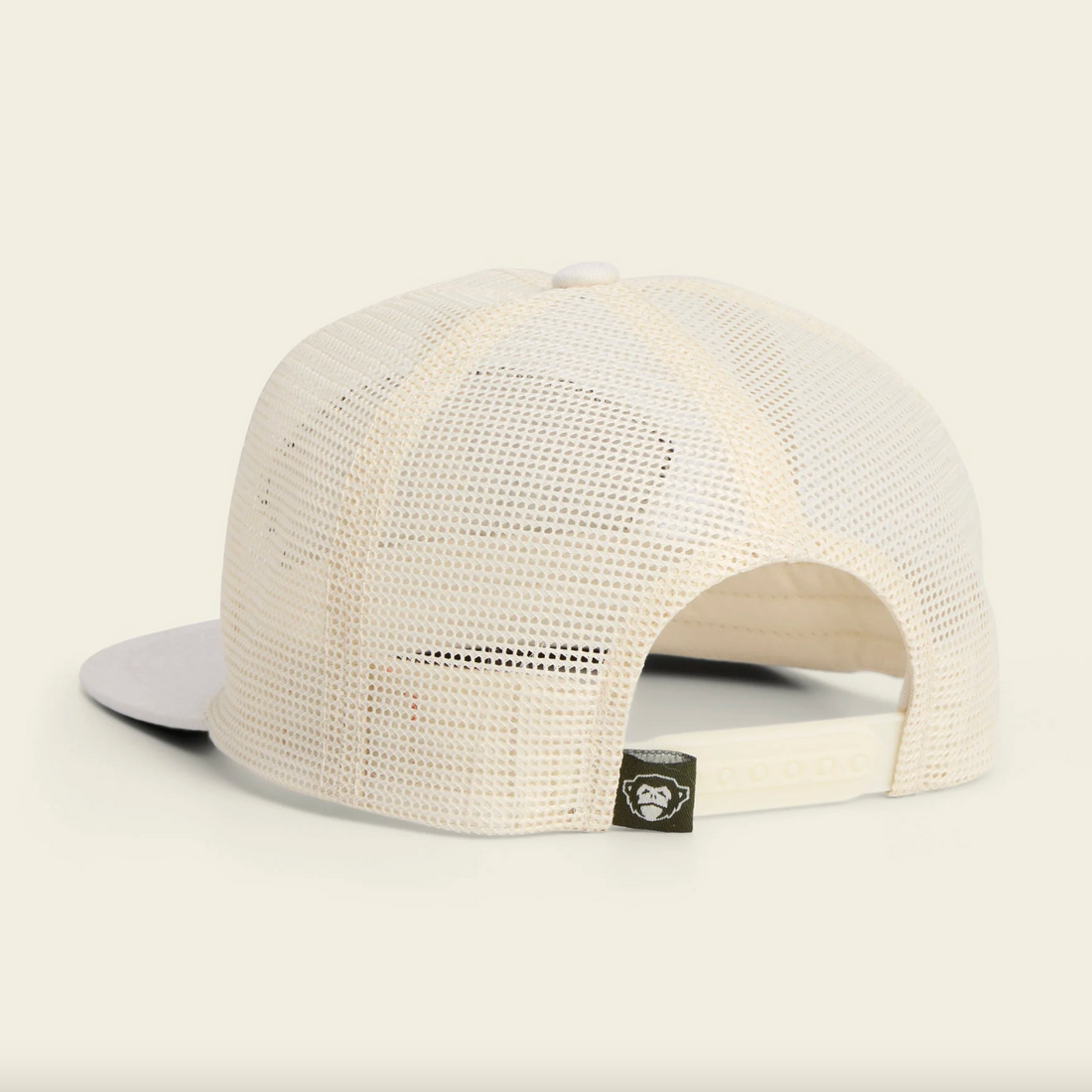 White mesh cap with Howler Brothers logo on a beige background