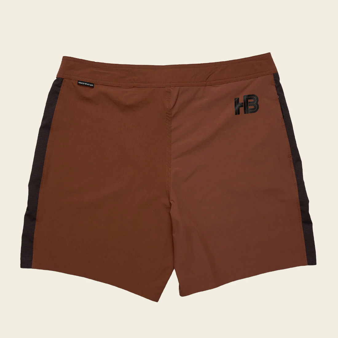 Brown shorts with black accents and logos on a beige background